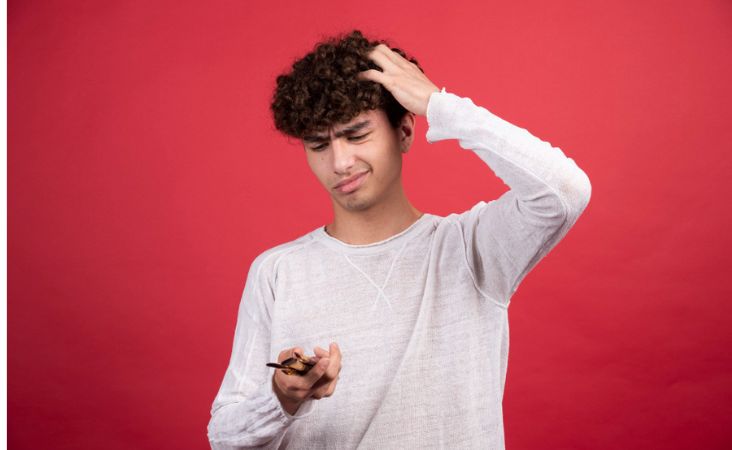 Young male scratching his head looking puzzled