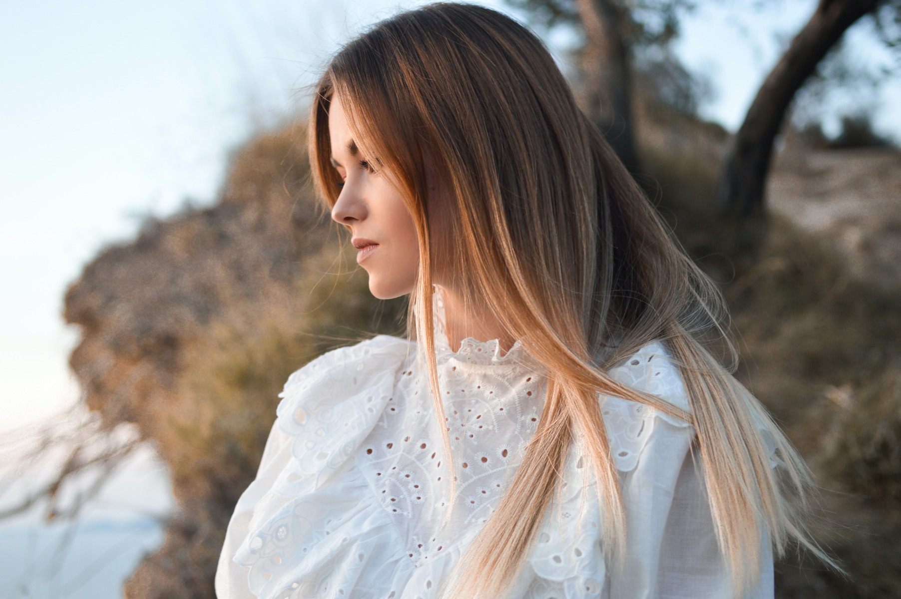 A pensive woman with long hair looking out into the distance