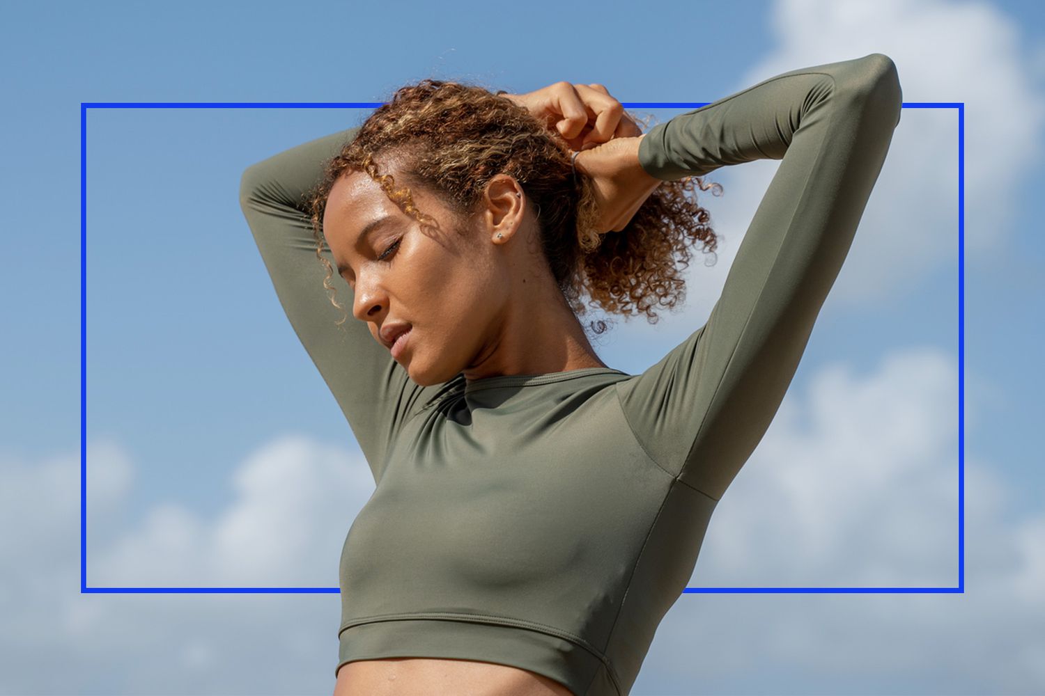 Woman in sports clothes playing with her protective hairstyle