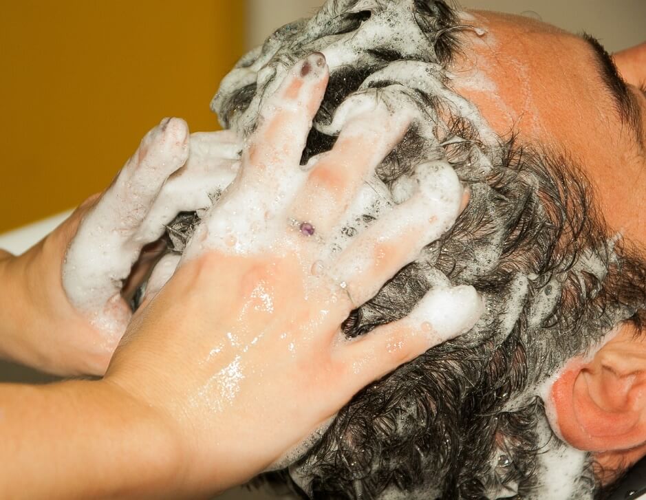 Shampooing a man's head