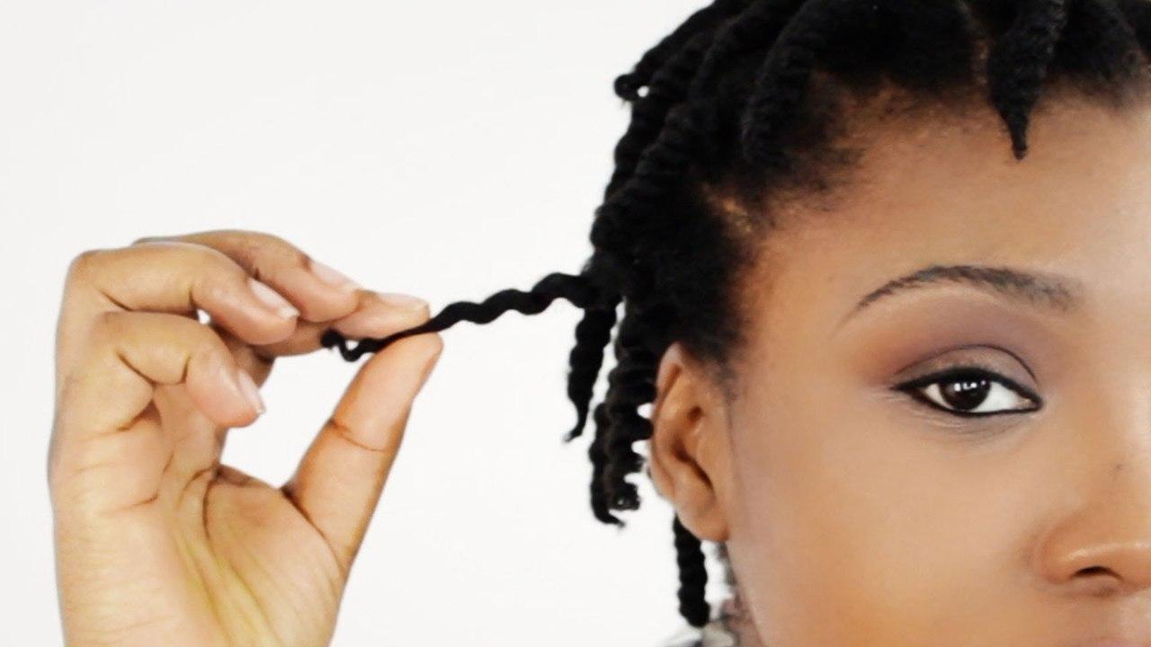 Woman playing with her twists and twists-out hairstyle