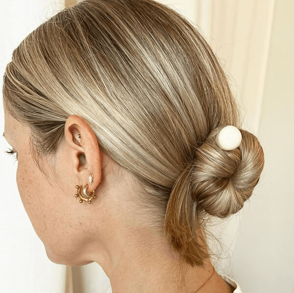 Blonde woman with hair in a top bun